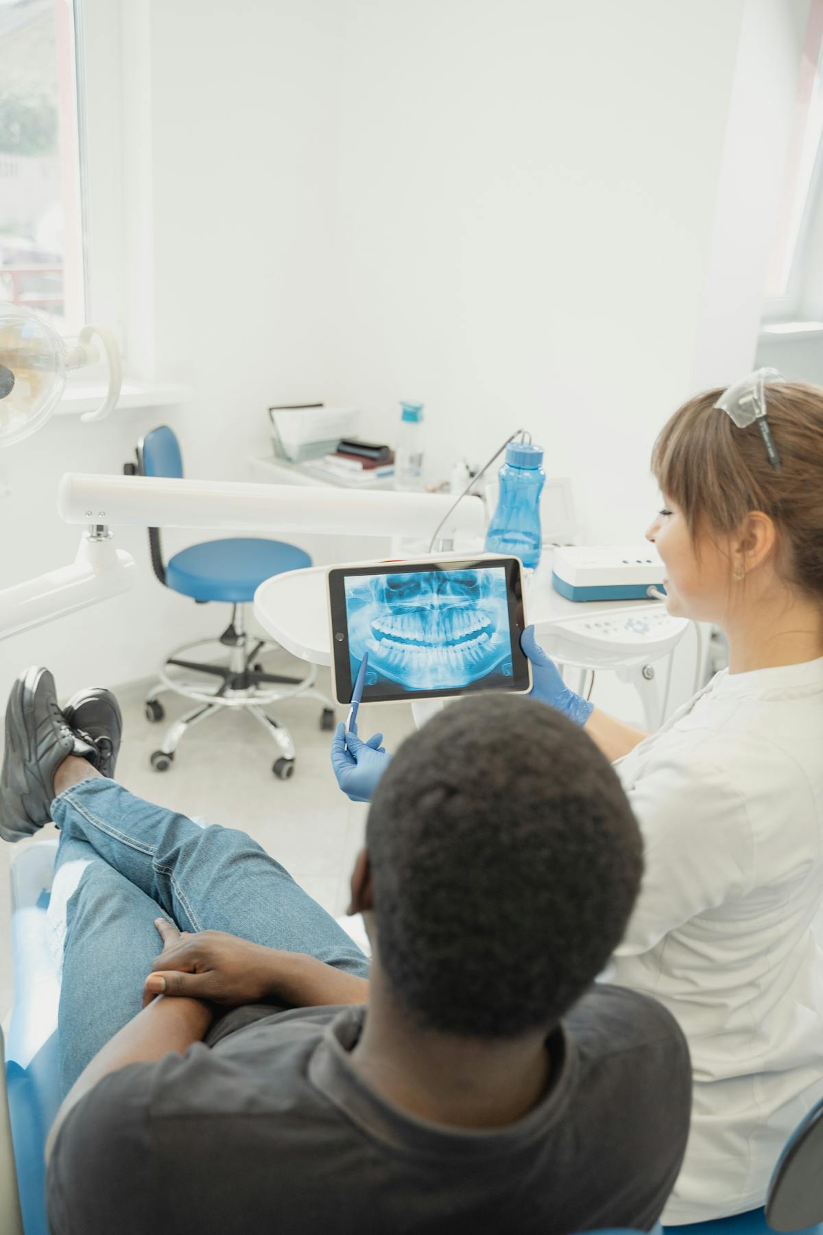 Indian dentist scrolling a patient chart on tablet before the chairside consultation
